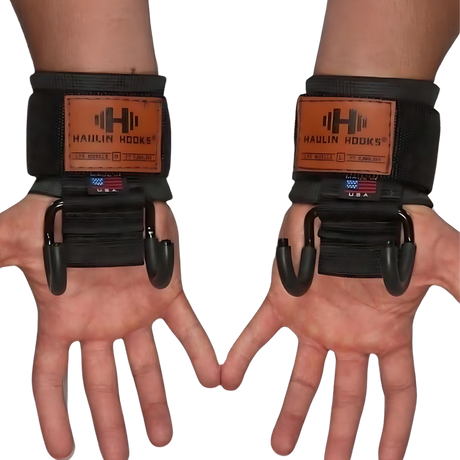 Two hands wearing HAULIN HOOKS ONLYS black wrist straps with metal lifting hooks, palms up, designed for superior muscle isolation and enhanced wrist protection.