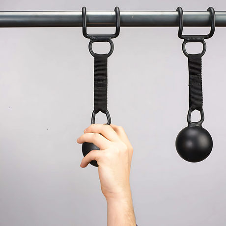 A hand grips a HOG LEGS 'Raging Boar' Pull-Up Grip, attached to a pull-up bar with a strap—perfect for enhancing grip strength during back workouts.