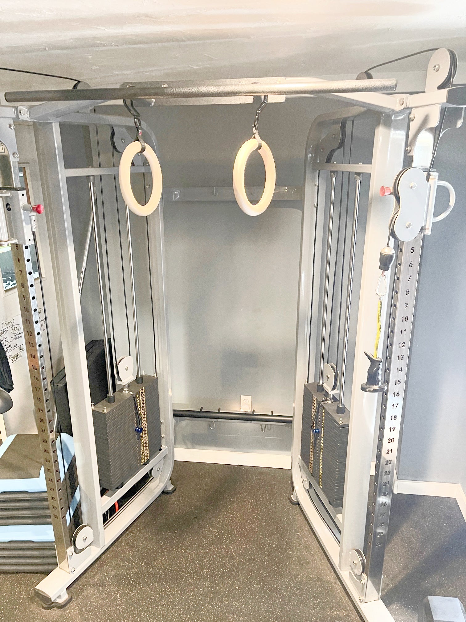 A cable crossover gym features GYMNASTICS RINGS Pull up Handles Roman Ring Pull Up Grips with wooden handles and gym rings in a bright fitness room.