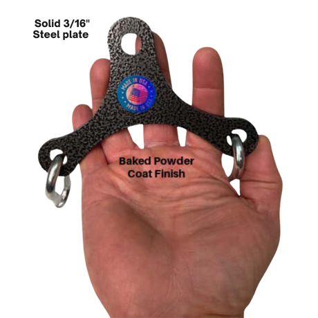 A hand holds the PULL FORCE Mini Multiplier Home Gym Cable Machine Yoke—a three-pronged black steel plate with rings, ideal for dual cable machines, featuring a "Made in USA" sticker and a lifetime replacement warranty.