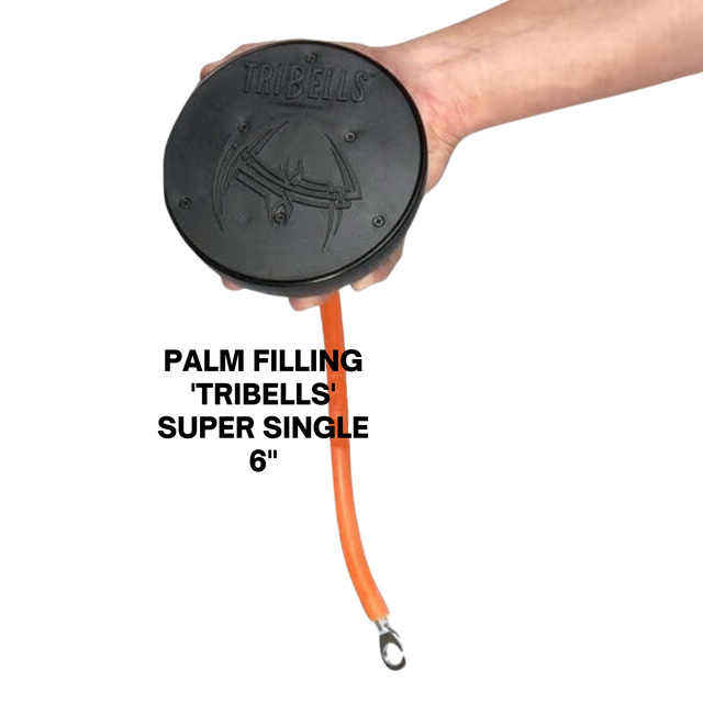 A hand holds the TRIBELLS 6" Palms Grip Tricep attachment—marked "TRIBELLS"—with an orange extension cable and metal loop, showcasing its clean, innovative design that outperforms traditional dumbbells.