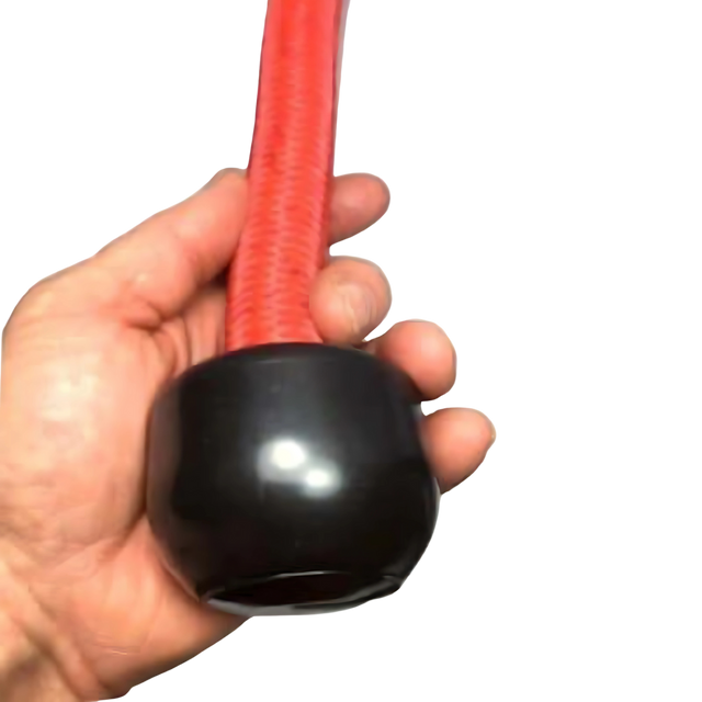 A hand holds the TRICEPS ROPE EXTREME 'Singles'—a red flexible triceps cable workout rope with a shiny black rounded cap and cushioned grip at the end.