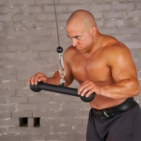 A muscular man uses a cable machine for an upper body workout in a gym.