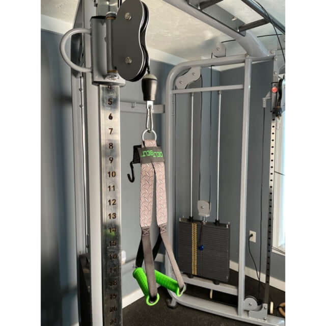 A gym pulley machine with adjustable weights and DELT-BELT Handle Straps in a blue-walled fitness room offers an ideal alternative to dumbbells for muscle-targeting cable exercises.