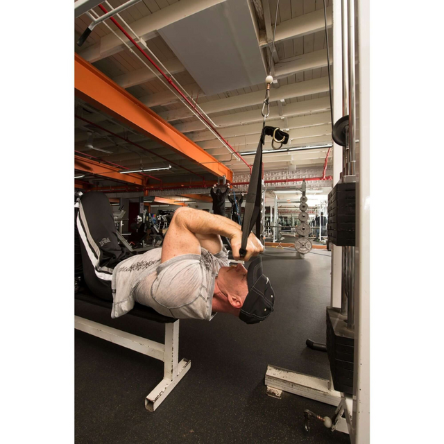 A man in the gym uses DELT-BELT Handle Straps on a cable machine for tricep extensions, showcasing the muscle-targeting effectiveness of cable exercises while lying on a bench.