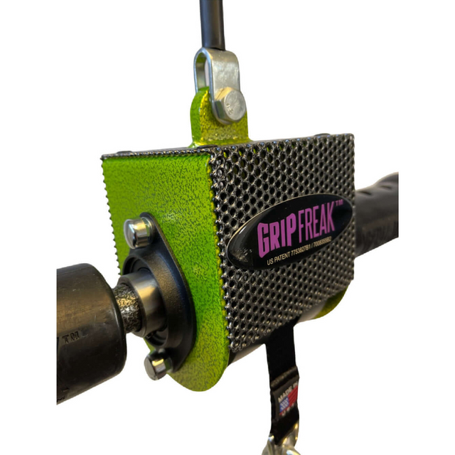 A close-up of a green GRIP FREAK Fat Grip WRIST ROLLER, with a textured surface, is expertly attached to gym equipment, offering intense crushing grip torque for your workouts.