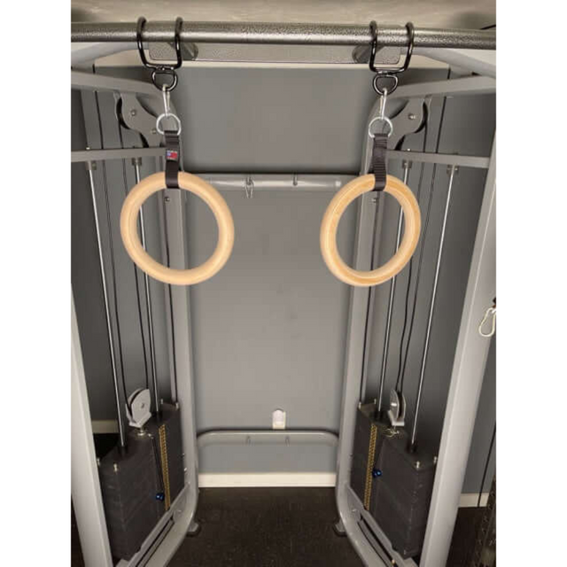 The GYMNASTICS RINGS Pull up Handles, crafted in the USA with superior grips, hang from a cable crossover machine in a professional gym setting.