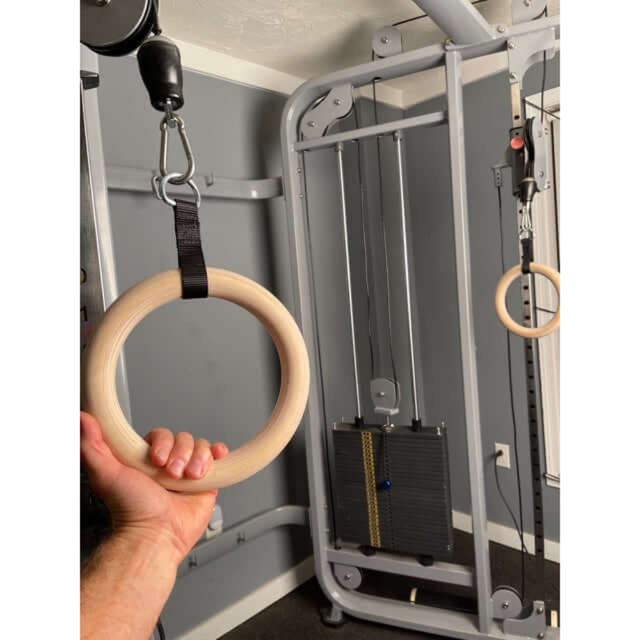 Someone uses the Gymnastic Rings Cable Machine Handles for a Roman Ring Workout in a gym setting.