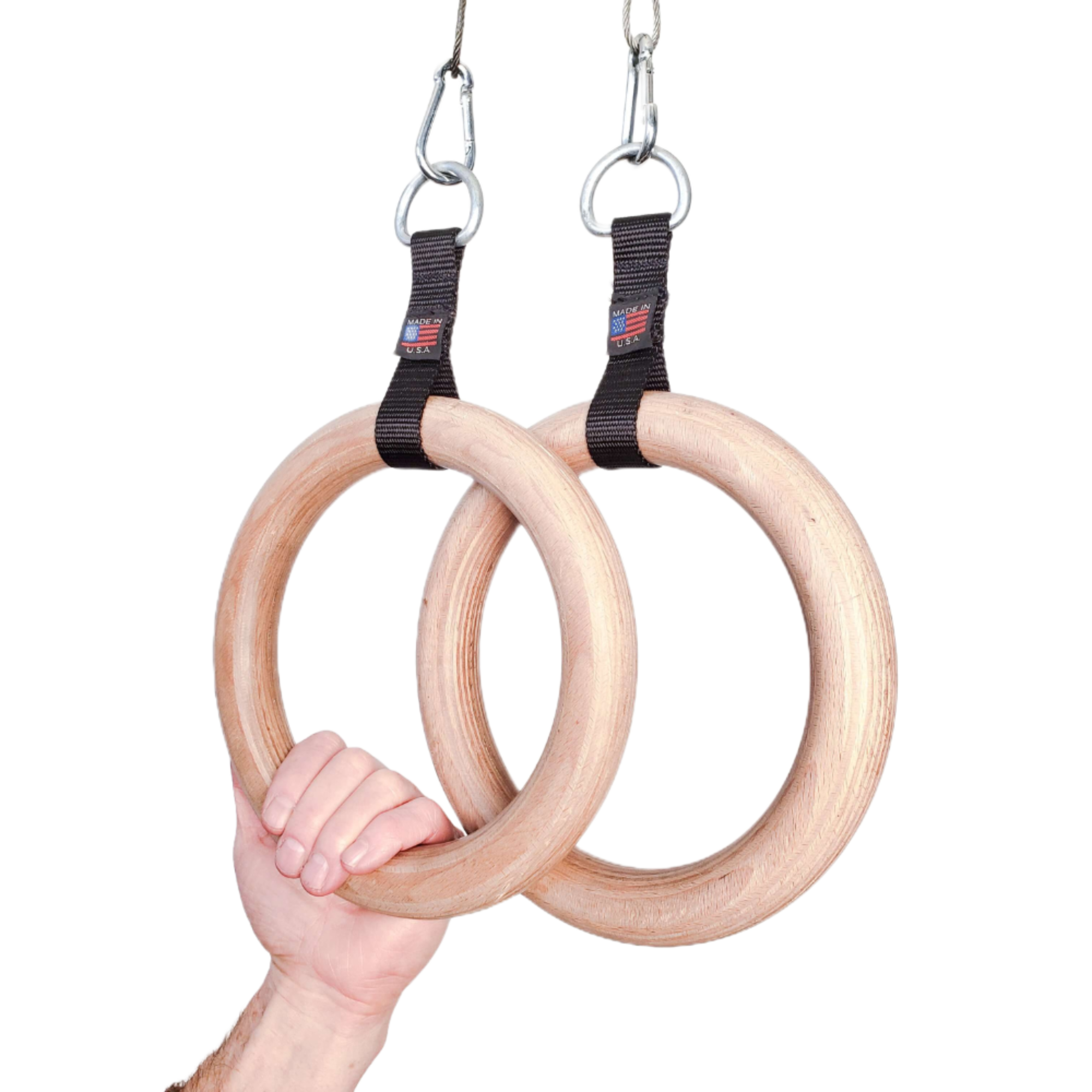 A hand grips the Gymnastic Rings Cable Machine Handles for Roman Ring Workout—sturdy wood rings with black straps and metal clips, highlighting the strength and elegance of this gym rings pair.