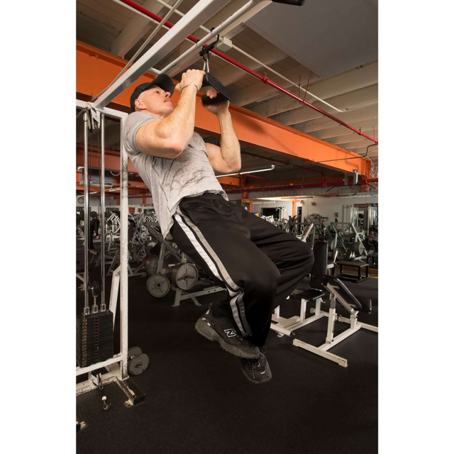 A person is doing a pull-up on a commercial-grade gym machine, wearing a gray shirt and black pants. They're using the HOG LEGS 'Back Pac' LEGIT Cable Machine Attachments Set, showcasing the power of USA-made equipment with training angles.