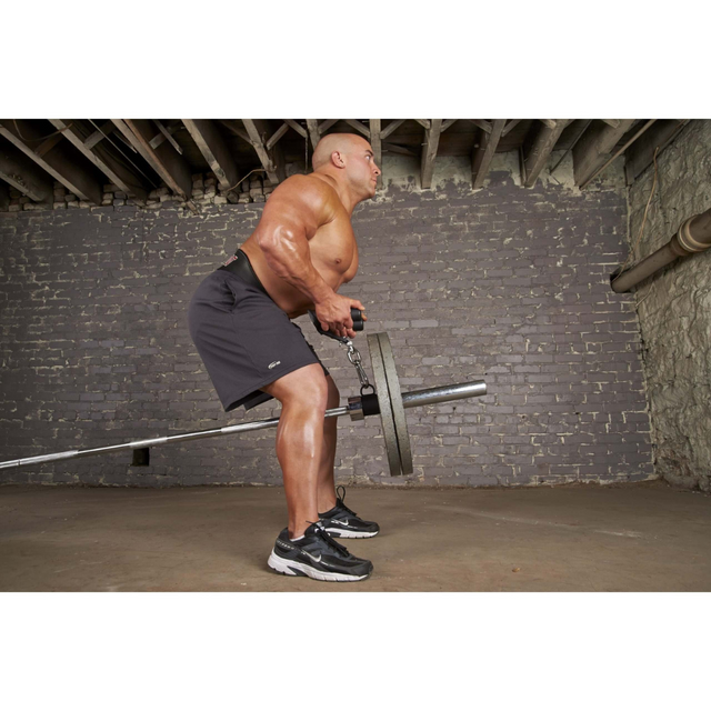 In a basement gym with rough walls and exposed beams, a person performs a barbell row using the HOG LEGS 'Back Pac' LEGIT Cable Machine Attachments Set.