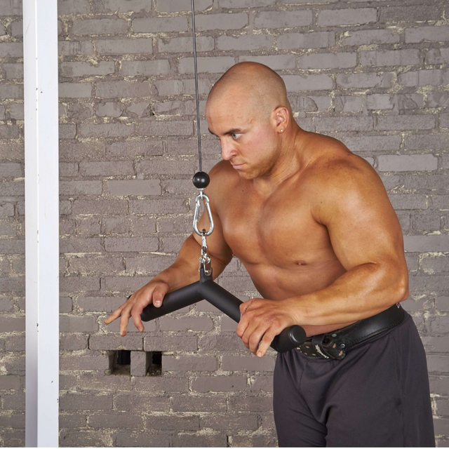 Using the HOG LEGS 'Feral Hog' Arm Workouts with Cables Bar set, a man effortlessly performs tricep pushdowns against a brick wall, showcasing the strength and precision to sculpt not only triceps but also forearms and biceps.