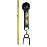 The HOG LEGS 'Fist Full' Pullup Handles & Tricep Attachment, a black handheld tool with hooks to boost grip strength, is adjacent to a yellow measuring tape on a white backdrop.