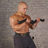 A muscular man uses HOG LEGS 'Hog Wild' Workout Cable Attachments gone Fat! for bicep curls, set against a rugged brick wall backdrop.