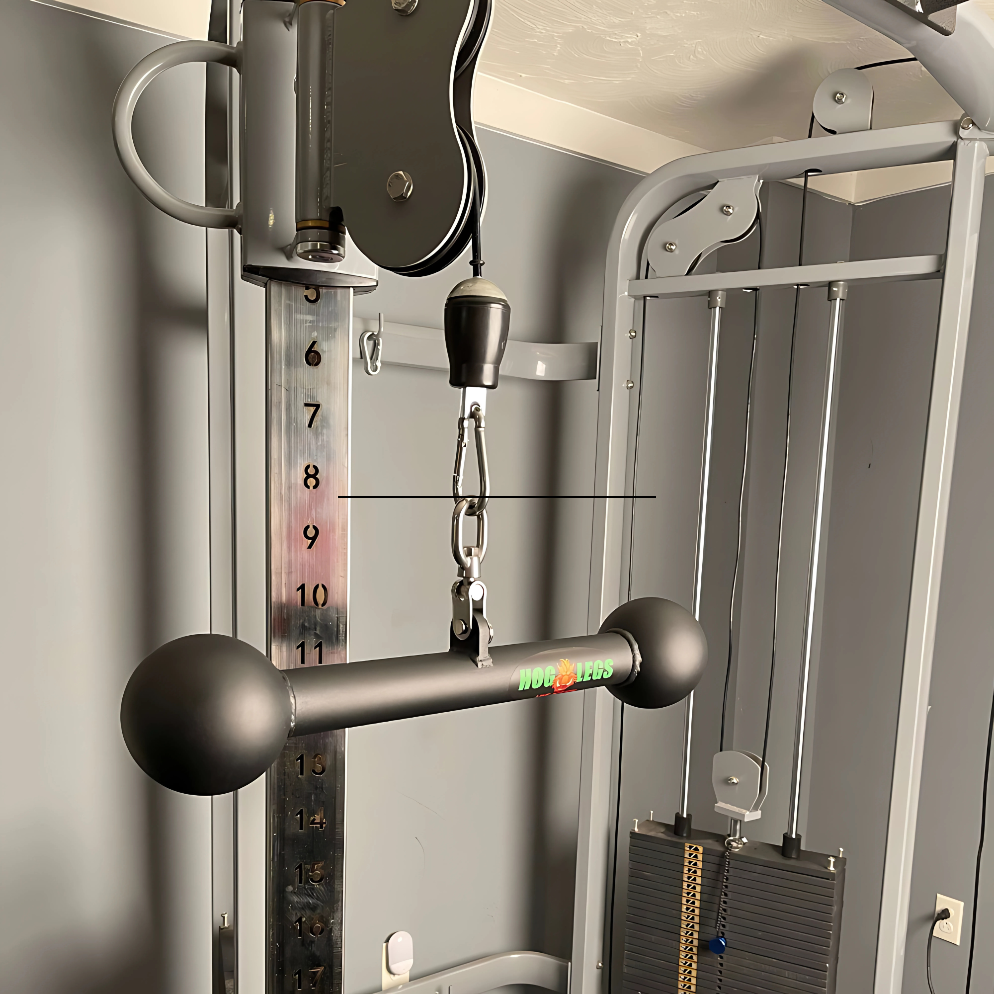 Close-up of the HOG LEGS Hog Balls Upper Body Exercise Equipment Bar attached to a cable machine with a visible weight stack, perfect for upper body workouts and boosting muscle engagement.