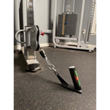 An HOG LEGS 'Jawbone' FAT Back Cable Workout Handle rests on the floor of a fitness room, ready to elevate any workout.