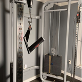Close-up of a cable machine in a gym, showcasing adjustable weights and HOG LEGS 'Jawbone' FAT Back Cable Workout Handles with stainless steel attachment rings.