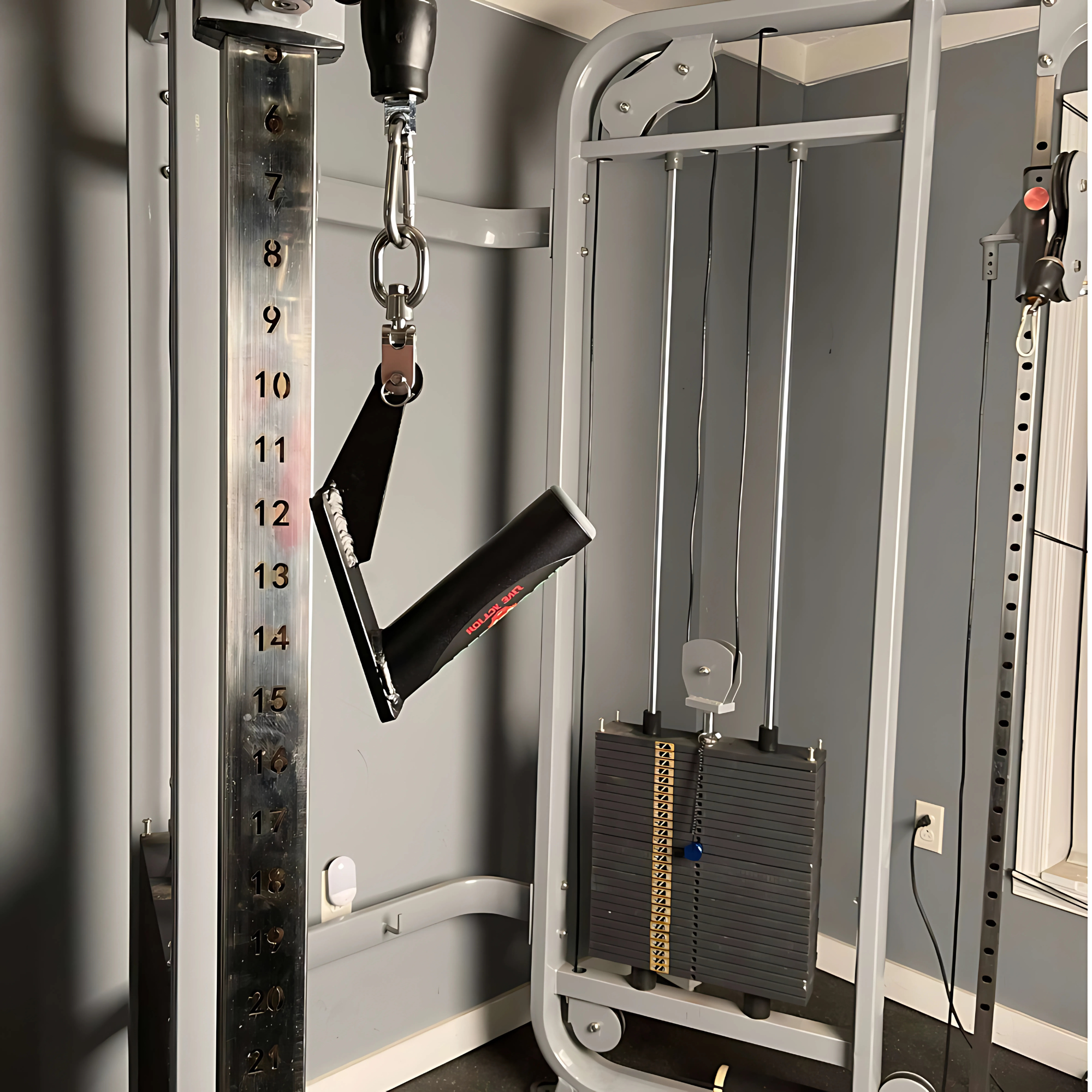Close-up of a gym cable machine with a V-handle and weight stack, ideal for using HOG LEGS Jawbone Fat Grip Gym Handles to boost your workout.