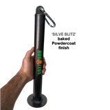 A hand holds a HOG LEGS Weight Load Pin / Weight Plate Holder, made of black metal with "HOG LEGS" text and a carabiner on top, ideal for strength training, set against a black background.