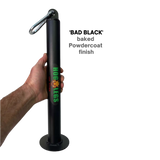 Hand holding a black HOG LEGS Weight Load Pin / Weight Plate Holder with "HOG LEGS" logo, text "baked Powdercoat finish," perfect for supporting Olympic Weight Plates during strength training setups.