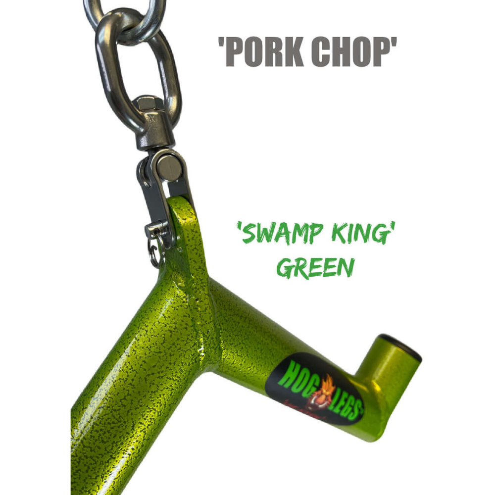 Close-up of a green metal object labeled "HOG LEGS 'Pork Chop'" and "Swamp King," similar to strong triceps extension gear, with a logo etched into its surface.
