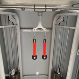 Two HOG LEGS Pull Up Hooks for Exercise Cable Attachments in red and black with a sleek powder coat finish hang securely from a patented hook in a gym setting.
