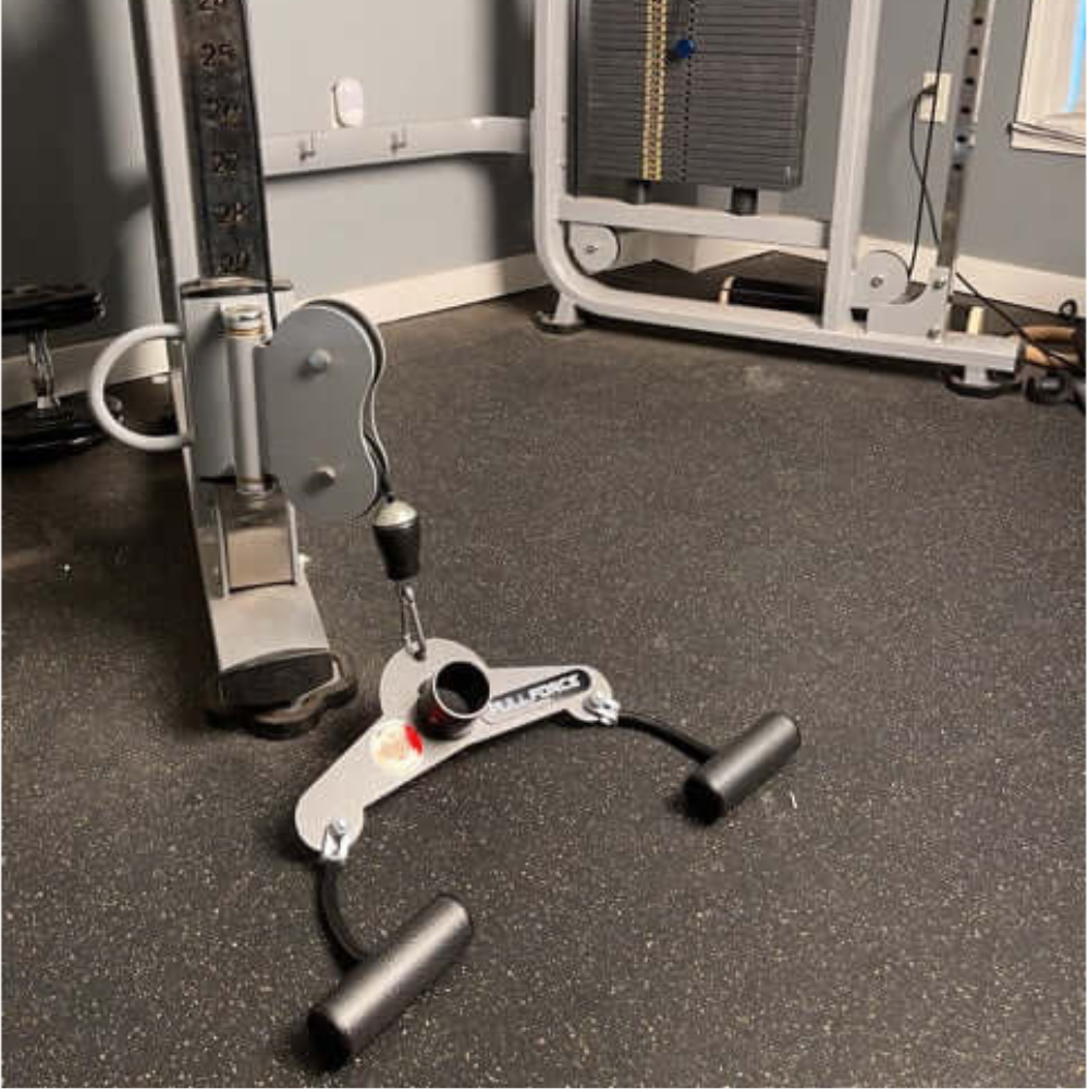 A gym cable machine with the PULL FORCE 'Combo' T Bar & Seated Cable Row Alternative, ideal for seated rows, rests on a dark rubber mat.