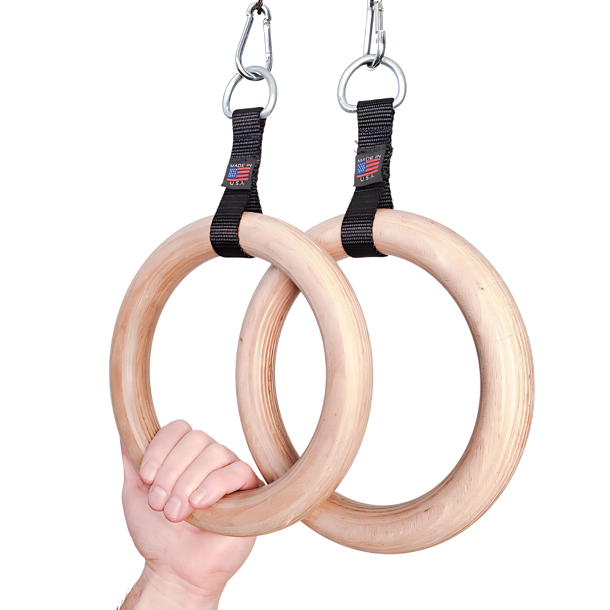 A hand grips two commercial-grade wooden gymnastic rings suspended by black straps and metal hooks—ideal for use with the PULL UP BAR WORKOUT 'Extreme pack' by LPGmuscle.