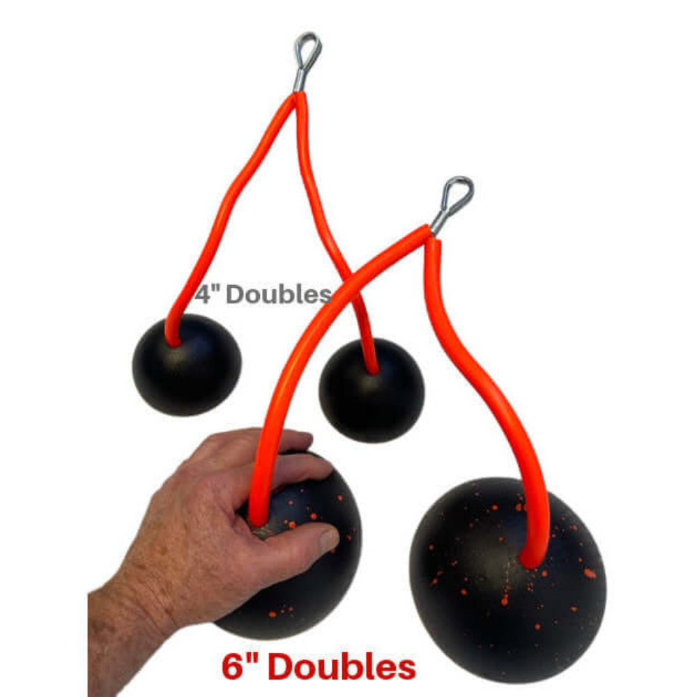 A hand grips the 6” TACTI-TRICEPS Double black weighted ball with a red handle, ideal for triceps exercises. Available in sizes like "4” Doubles," these ergonomic gym handles elevate your workout routine.