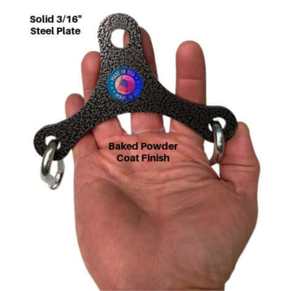 A hand holds the TRD 'Dynamic Action' Yoke Triceps Attachment Gym Handles—a black, three-pronged solid 3/16" steel plate with rings and a baked powder coat finish for rugged cable machine workouts.