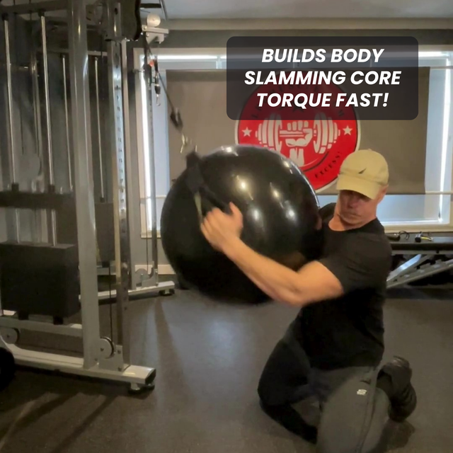 Man kneeling in gym, slamming large black ball with text: "PHYSIO TWIST Swiss Ball Handle Straps for Cable Machine Core—build explosive core power and torque fast!.